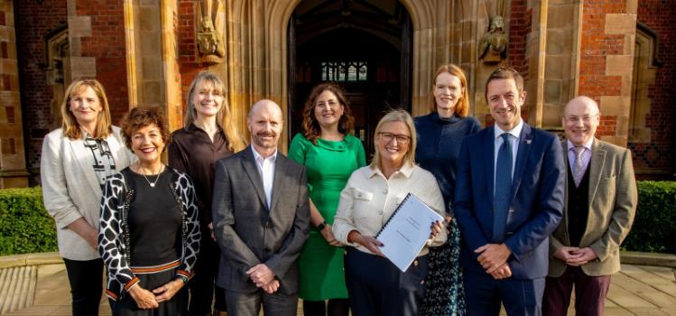 Representatives from Queen's and the Belfast Trust pictured in front of the Lanyon building on a sunny day